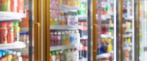 supermarket convenience store refrigerators with soft drink bottles on shelves abstract blur background