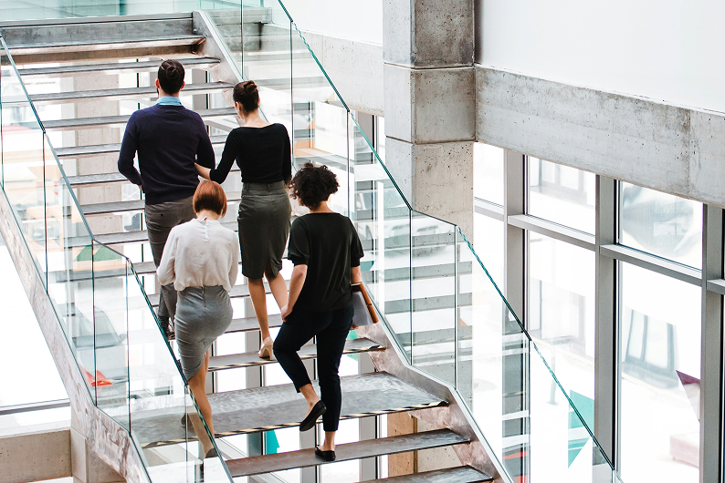Professionals ascending stairs in a modern corporate office